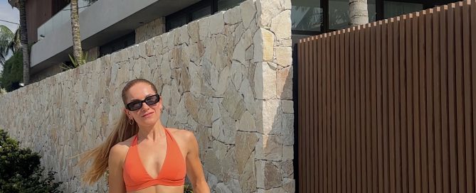 Cat Martin – Your Daily Habits Create Your Reality – fitness lifestyle photo in orange crop top and black Lululemon leggings